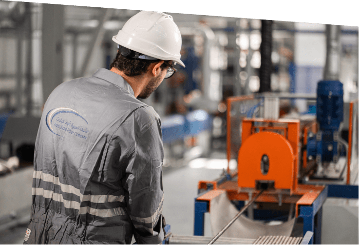 Arab Basalt Fiber Company worker in protective gear supervising machine operations